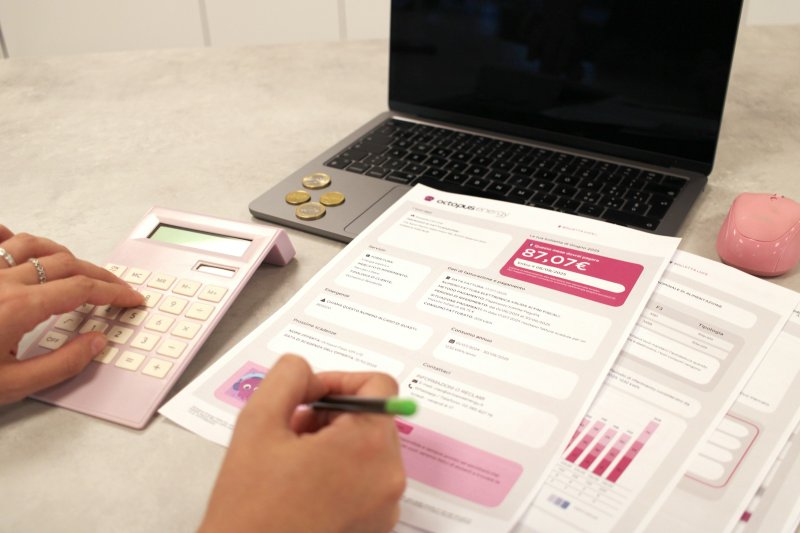 Homeowner working through an energy bill with a calculator and laptop on a desk