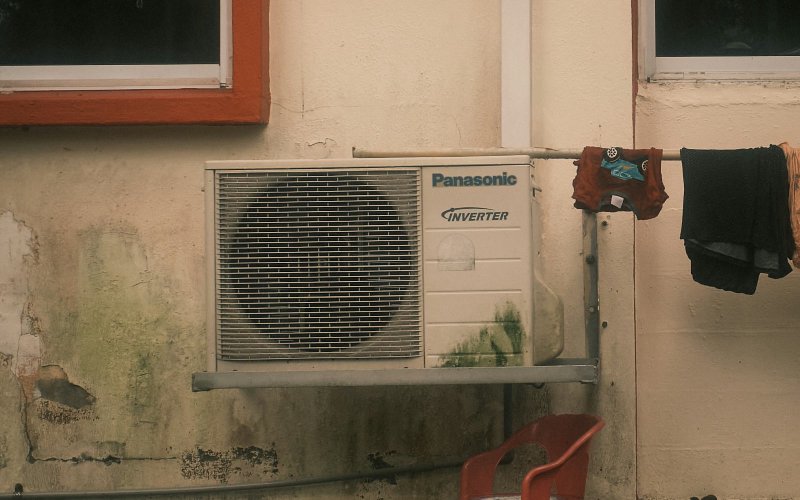 Wall-mounted split-system air conditioner unit on a weathered exterior wall