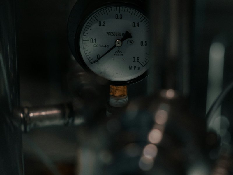 Analog pressure gauge mounted on metal piping with MPa scale