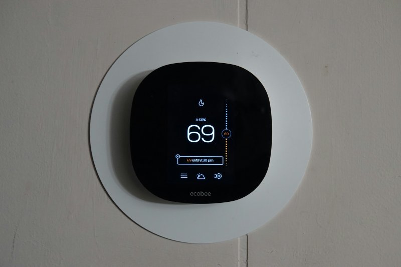 Wall-mounted ecobee smart thermostat displaying 69 degrees on a black screen with humidity reading