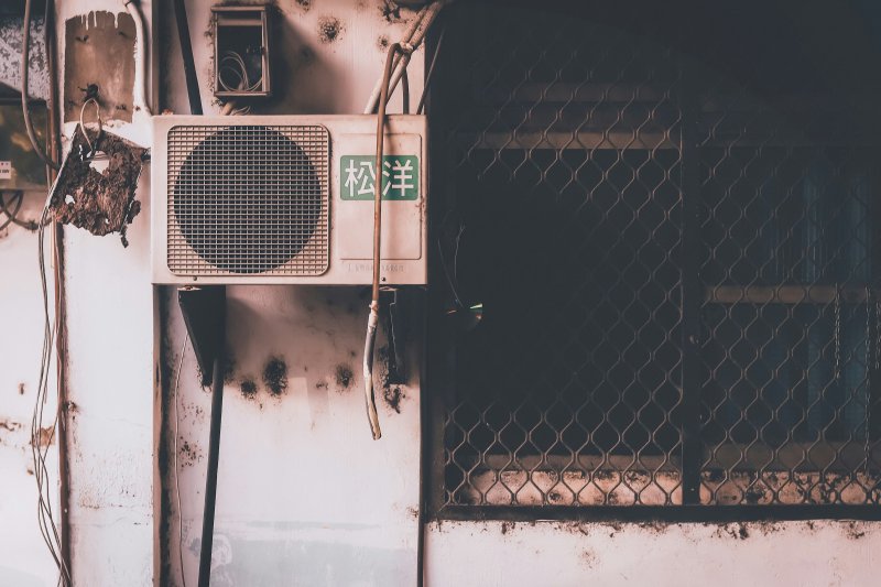 Old weathered air conditioner unit on an aged exterior wall
