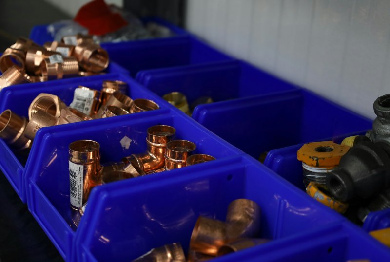 Bins of copper plumbing fittings (elbows, tees, couplings) on a workshop bench