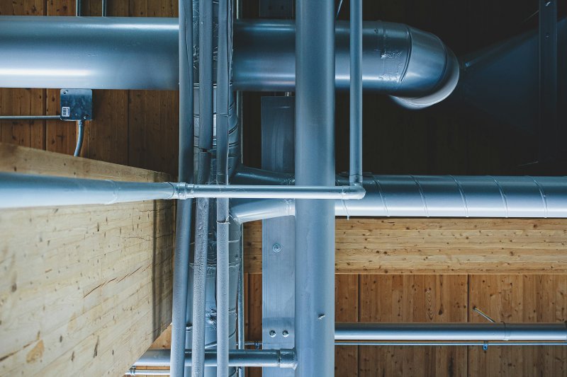 Metal supply pipes routed through a wood-framed ceiling cavity