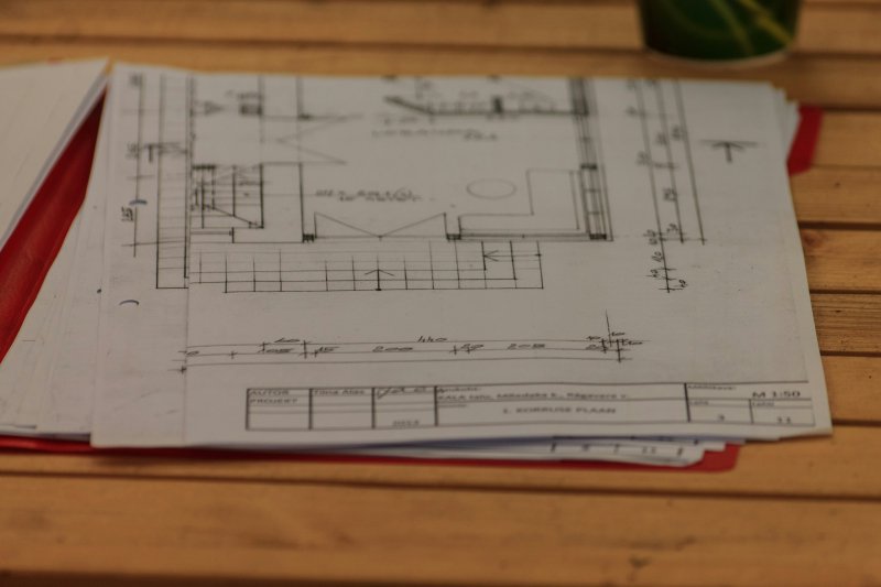 Architectural blueprint of a residential floor plan on a wooden table