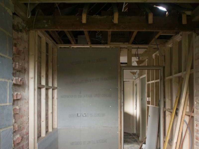 Bathroom shower under construction with cement backerboard walls and a poured shower base ready for membrane and tile
