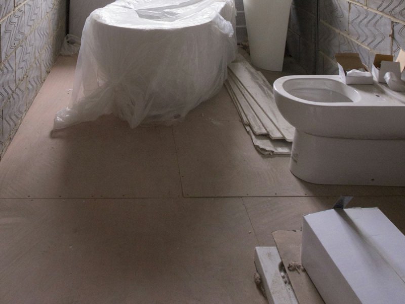 Bathroom mid-remodel with new fixtures roughed in and tile walls partially finished