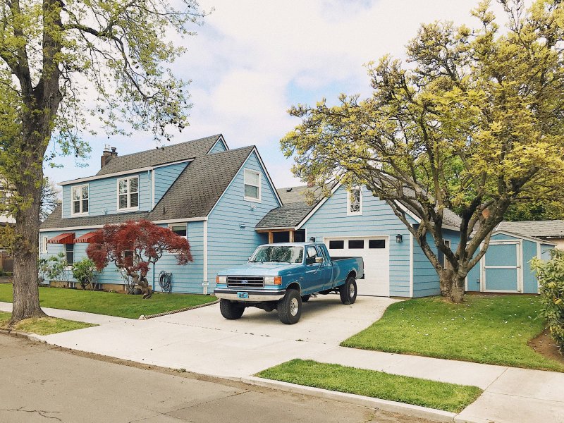 Service pickup truck parked on a concrete driveway in front of a residential house with a white garage door