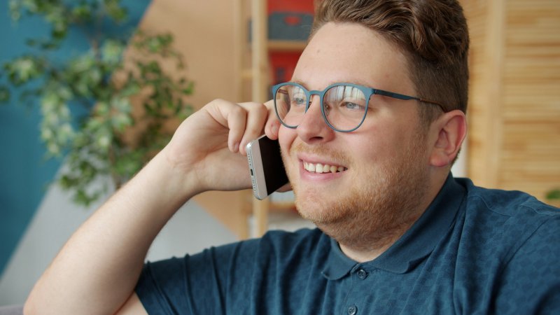 Homeowner holding a smartphone to his ear during a phone call to a service dispatcher