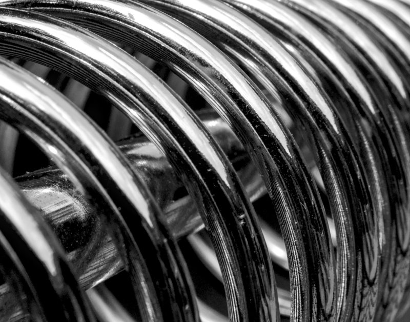Close-up of a tightly wound metallic torsion spring showing its coiled structure