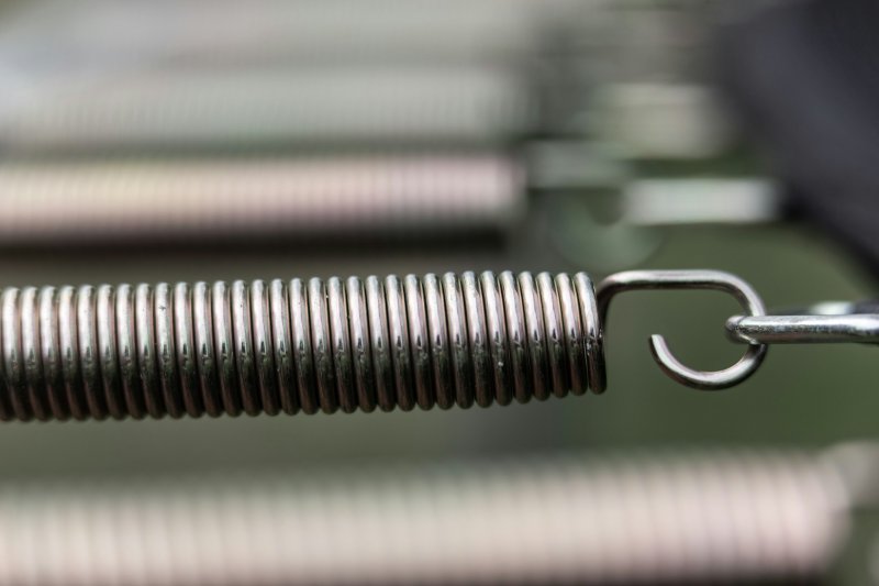 Close-up of a metallic coil spring with a hooked end