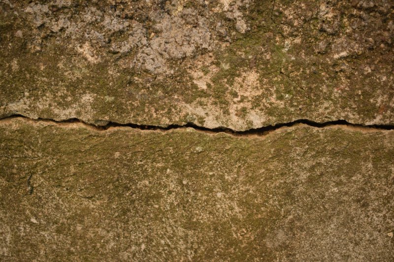 Horizontal crack across a weathered concrete wall