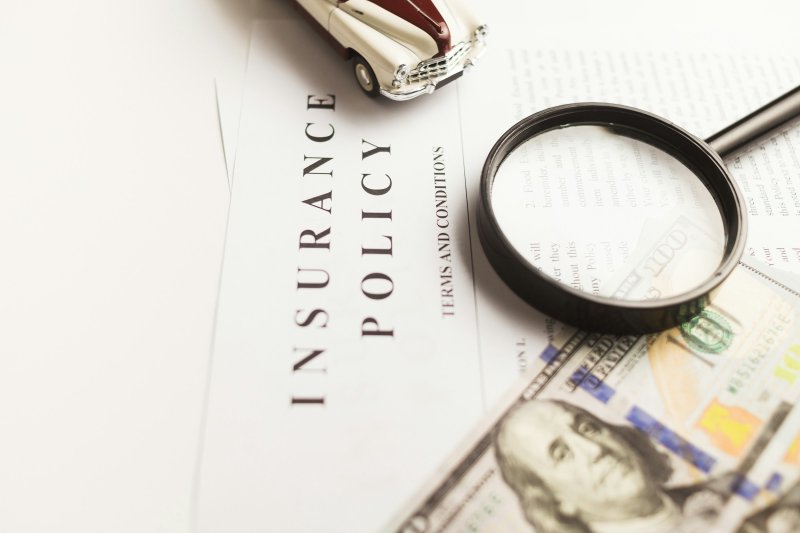 Insurance policy document under a magnifying glass with terms and conditions visible