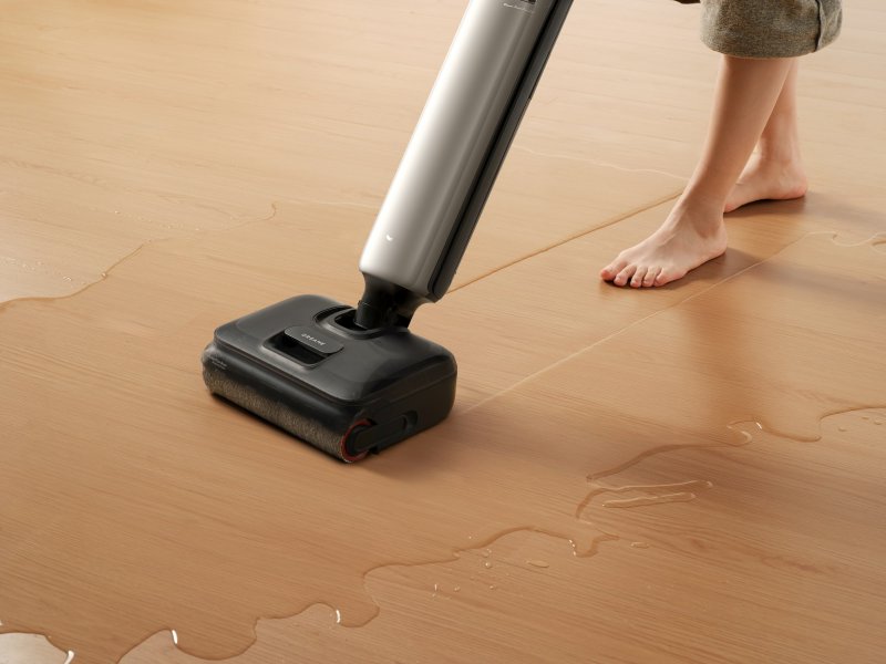 Wet mop and pooled water on a wooden floor during a small-loss extraction