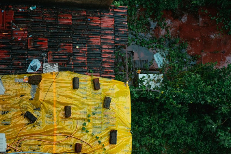 A yellow tarp covers a damaged roof section after a storm